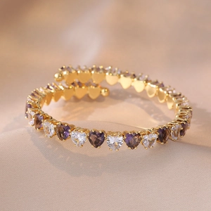 Detailaufnahme des Herz-Zirkonia-Armbands in Violett und Weiß mit Goldsockel
