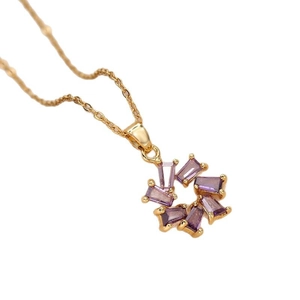 Elegante goldene Titan-Halskette mit lila Zirkon-Blumenanhänger auf weißem Hintergrund
