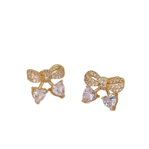 Elegant gold bow earrings with heart-shaped zircon cherry drops on white background