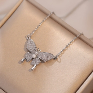 Collana con ciondolo a farfalla con perle e zirconi su velluto color champagne