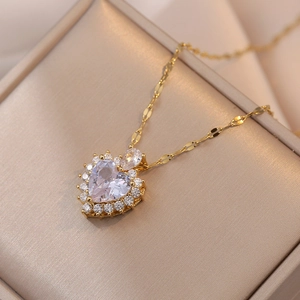 Close-up of a luxury gold heart necklace featuring a clear zircon pendant with pavé halo