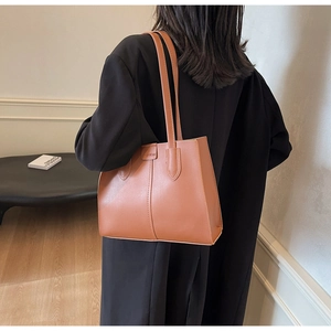 Brown leather tote bag featuring vertical stitching and fashion embossed lettering