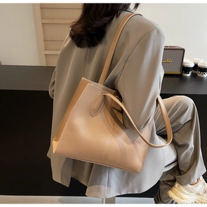 Detail of minimalist leather tote bag with fashion label and side stitching texture