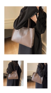 Detail of a large brown PU leather tote bag with FASHION embossed logo and dual handles