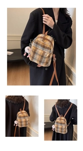 Detail of plaid wool mini backpack with brown leather straps and pink plush pendant