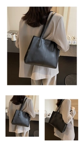 Detail of embossed FASHION lettering on a large black faux leather tote bag