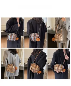 Detailed views of vintage plaid wool bucket bags with plush puppy charm and woven handles