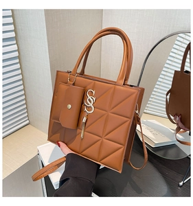 Detail of caramel tote bag featuring quilted triangle pattern and gold S charm