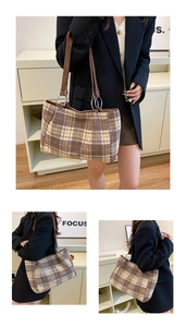 Detail view of plaid felt tote bag featuring brown leather handles and silver metal rings
