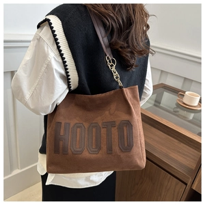 Brown suede tote bag featuring leather handles and gold metal chain details