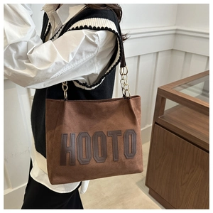 Detail of brown matte shoulder bag with HOOTO embossed logo and chain leather strap