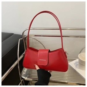 Detail of red crescent shoulder bag featuring smooth glossy leather and silver buckle