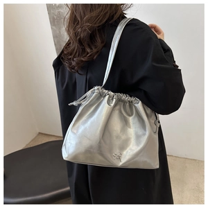 Detailed view of stylish metallic silver soft leather shoulder bucket bag with drawstring.