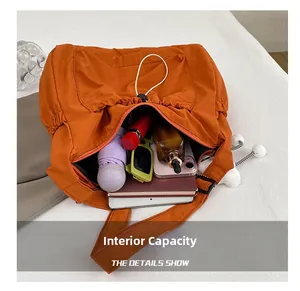 Internal capacity of the orange nylon shoulder bag showing tablet and daily items