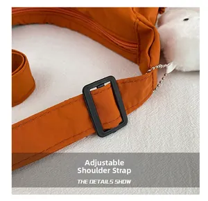 Detail of adjustable nylon strap with plush pendant and water-repellent fabric texture