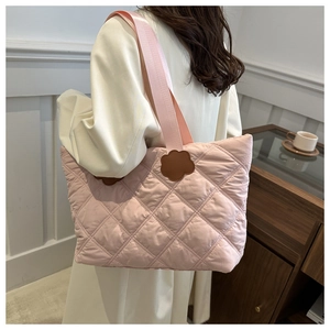 Detail of light pink quilted tote bag with brown flower patches and soft nylon strap