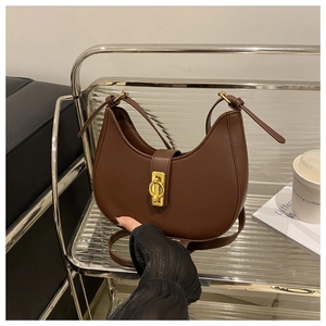 Detail of dark brown hobo shoulder bag with golden ring buckle and knotted strap design