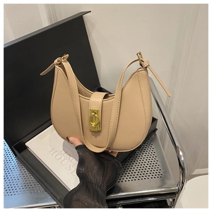 Detail of the milk tea leather saddle bag featuring a stylish golden twist lock closure