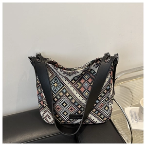 Détail d'un sac hobo tissé ethnique aux motifs géométriques colorés et bandoulière noire