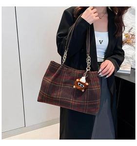 Detail of vintage plaid woolen tote bag with leather strap and cute animal charm