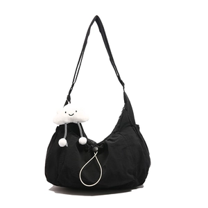 Minimalist black nylon crescent shoulder bag with white cloud plush pendant accessory