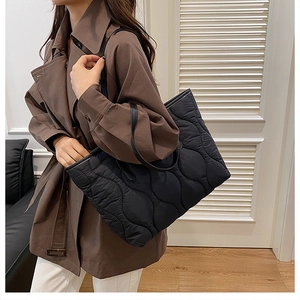 Détail du sac cabas matelassé noir montrant sa grande capacité et sa texture ondulée