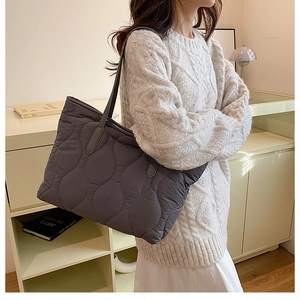 Détail du sac cabas matelassé gris foncé avec coutures ondulées et texture nylon