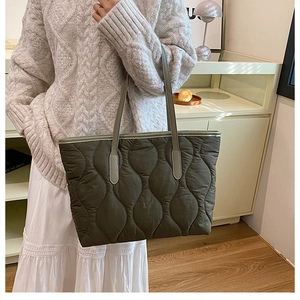 Vue macro du sac fourre-tout matelassé vert olive avec motifs ondulés et grande capacité