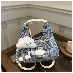 Detail of blue and white striped canvas handbag with fashion tag and cloud charm
