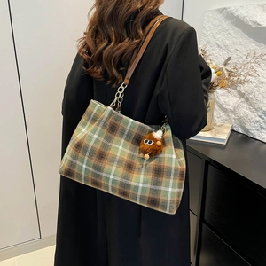Retro green plaid woolen tote bag with leather strap and plush bear charm on model