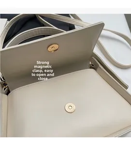 Detail van beige lederen schoudertas met een sterk gouden magnetisch sluitingssysteem
