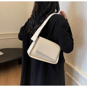 Minimalistische crème schoudertas getoond op model voor maat en stijl referentie