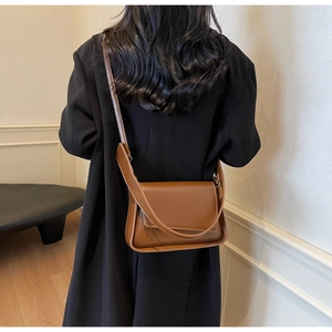 Minimalistische donkerbruine leren schoudertas met rechthoekige flap en glanzende afwerking