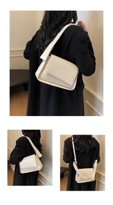 Detail van een crème crossbodytas van PU-leer met brede riem en goudkleurige gesp