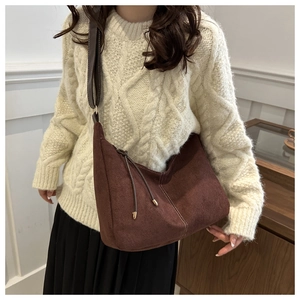 Détail du sac bandoulière en daim marron avec franges et finitions métalliques