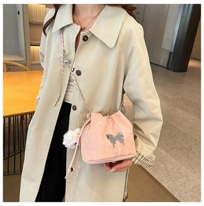 Pink bucket bag with silver butterfly charm and chain strap shown on a model