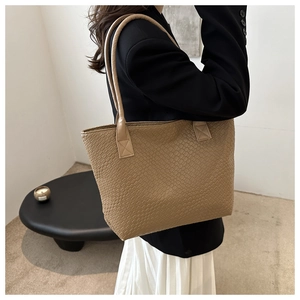 Macro detail of khaki woven texture and faux leather material on large tote bag