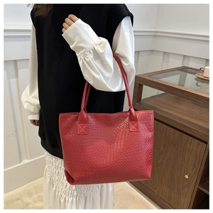 Detail of red woven texture on a minimalist PU leather tote bag with sturdy stitching