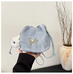 Light blue bucket bag detail with textured finish and large silver metal butterfly