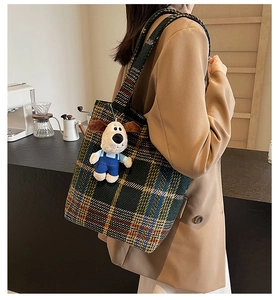 Detailansicht einer karierten Stricktasche mit Hundeanhänger an einem Schultergurt