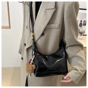 Glossy black patent leather tote bag with bear charm and maisone embossed logo
