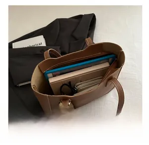 Spacious brown tote bag interior showing storage for tablet, books, and sunglasses