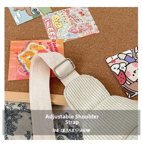 Detailed macro view of the adjustable shoulder strap and metal buckle on corduroy bag