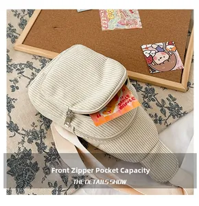 Close-up of front zipper pocket on beige corduroy crossbody bag showing storage capacity