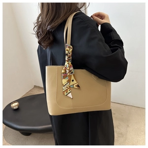 Detail of apricot tote bag with decorative silk scarf and neat stitching on smooth leather