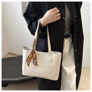 Detail of off-white tote bag with silk scarf accent and premium leather texture