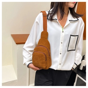 Detailed view of brown corduroy belt bag showing dual zip layers and canvas strap on model