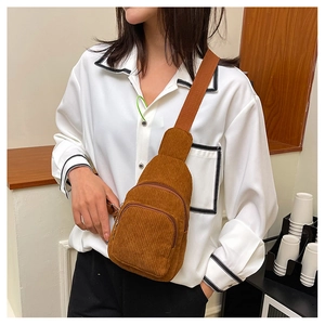 Brown corduroy crossbody chest bag with adjustable strap worn by model in casual style