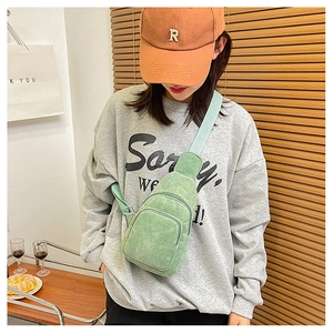 Casual light green corduroy crossbody bag worn by model in a minimalist lifestyle setting