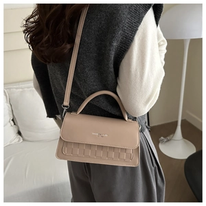 Detail showing the beige PU leather handbag with checkered texture and silver metal hardware